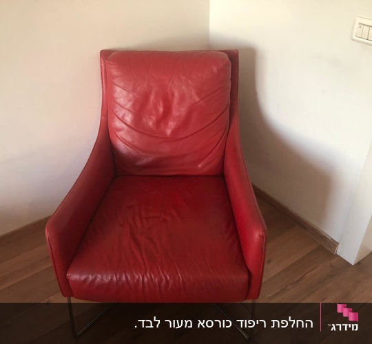 כורסה אדומה עם ריפוד עור על רצפת עץ